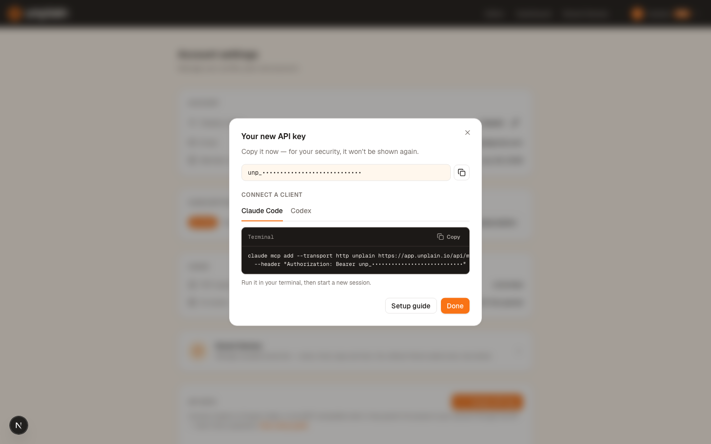 The Unplain account settings dialog showing a newly created API key and the claude mcp add command with the key already filled in